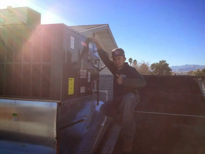 HVAC technician performing Boiler Repair on a rooftop unit in Marshalltown